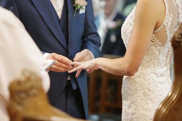 The bride and groom exchange rings during their wedding ceremony.