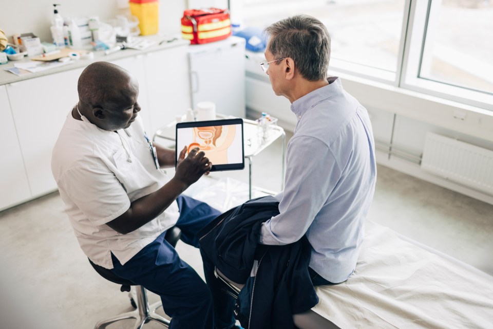 Doctor showing prostate diagram on tablet to patient.