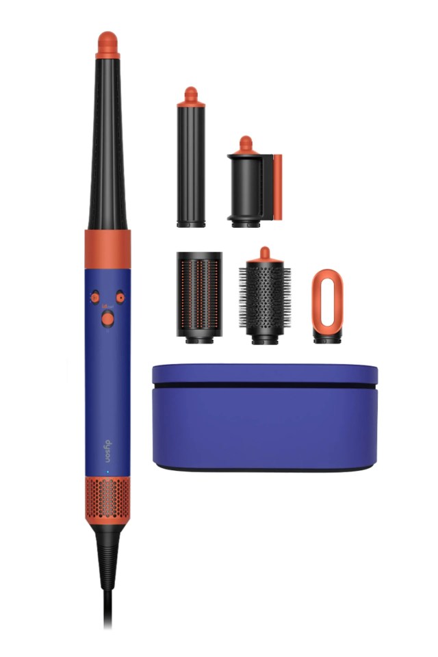 Dyson hair styling tool with various attachments and storage case.