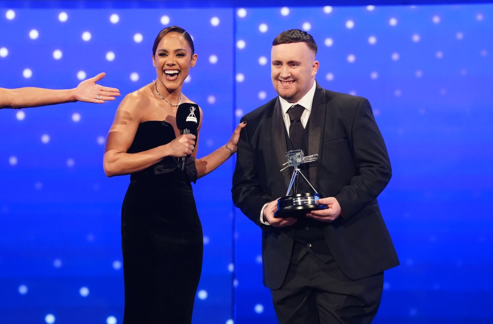 Luke Littler accepts the BBC Young Sports Personality of the Year award from Alex Scott.