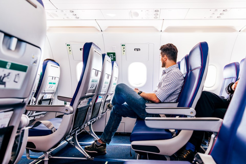 Man sitting by the window on a commercial airplane.