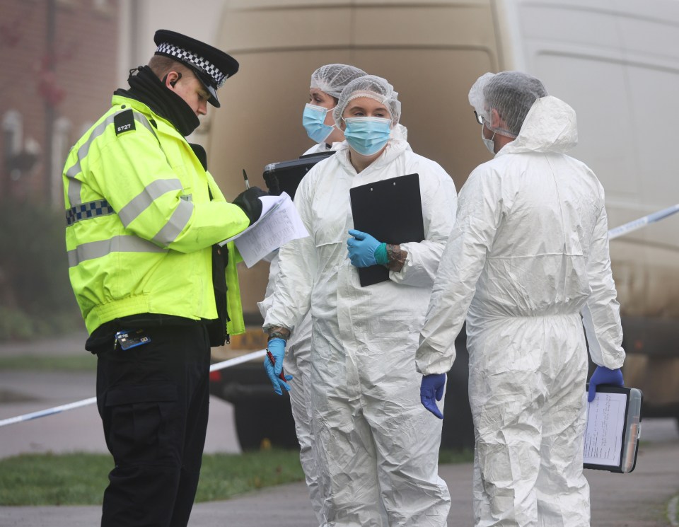 Police officer and forensic investigators at a crime scene.