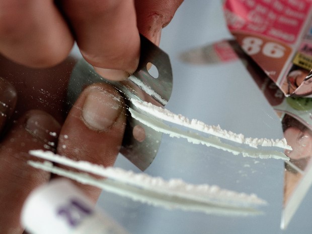 Close-up of a person snorting cocaine.