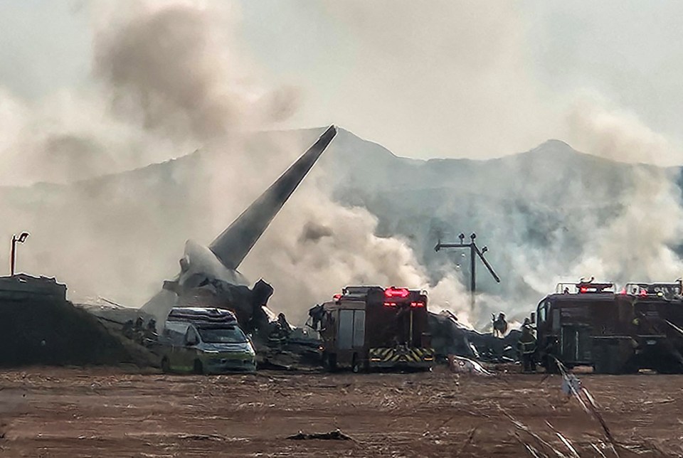 Smoke rises from the rubble as firefighters put the blaze out