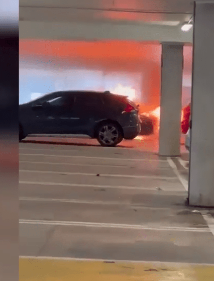 Car on fire in parking garage.