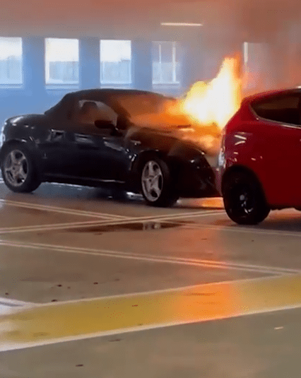 Car on fire in parking garage.