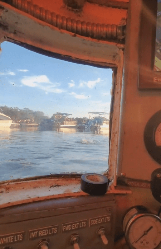 View from a submarine's porthole showing a body of water and docks.