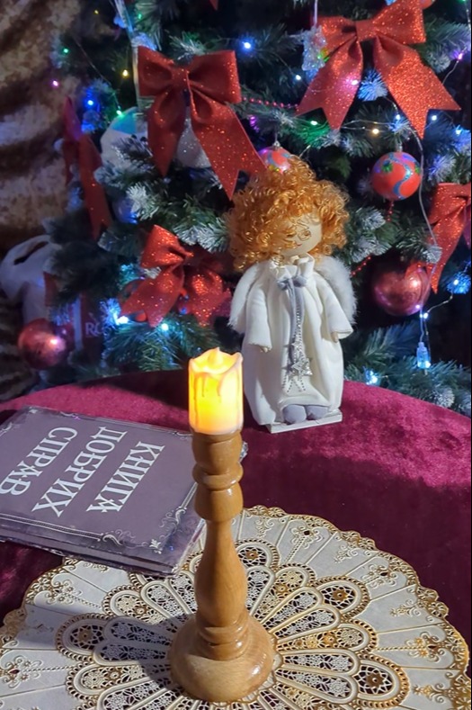 A candle, an angel and a book sit on the table in the centre of the main grotto room