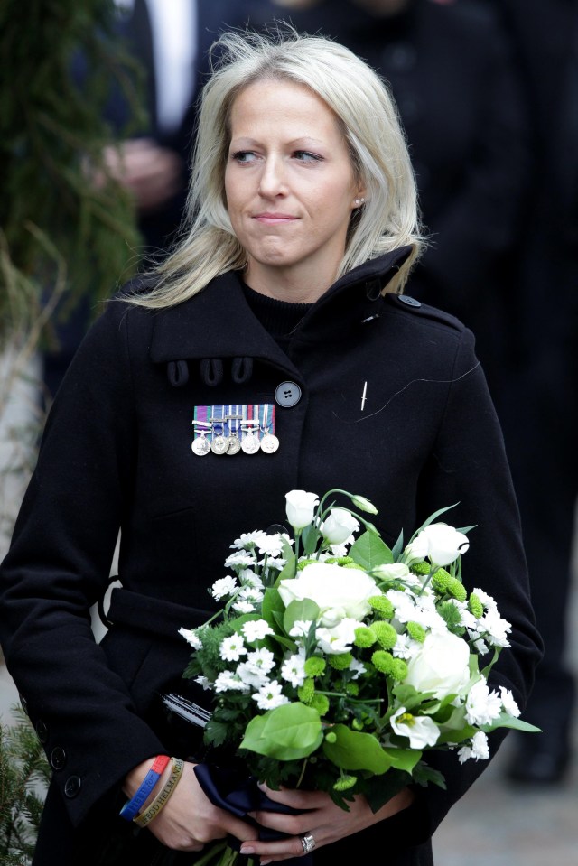 Christina Schmid, wearing her late husband's medals, arrives at court accused of assault.