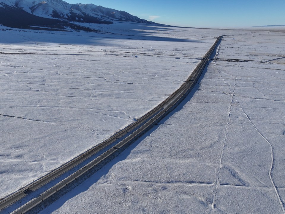 An aerial photo shows a highway crossing the East Tianshan Mountain after snow in Hami, Xinjiang province, China