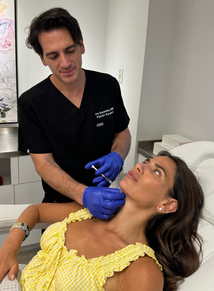 A plastic surgeon injects a patient's jawline.