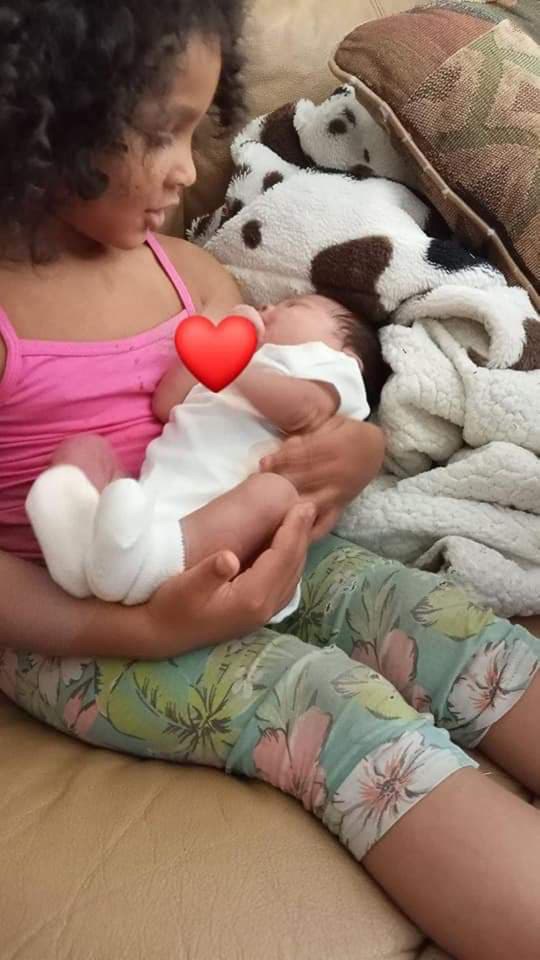 Annie holding her baby sister, Aalijah when she was born