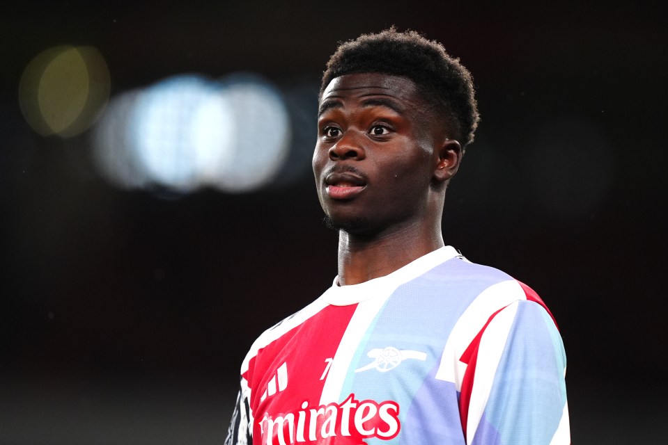 Bukayo Saka warming up in an Arsenal jersey.