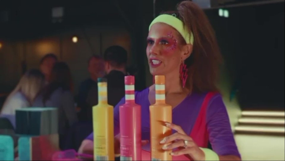 Becky features in the promo with bottles of booze