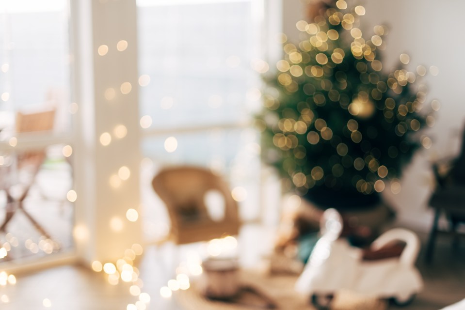 Blurry image of a Christmas tree with lights in a living room.