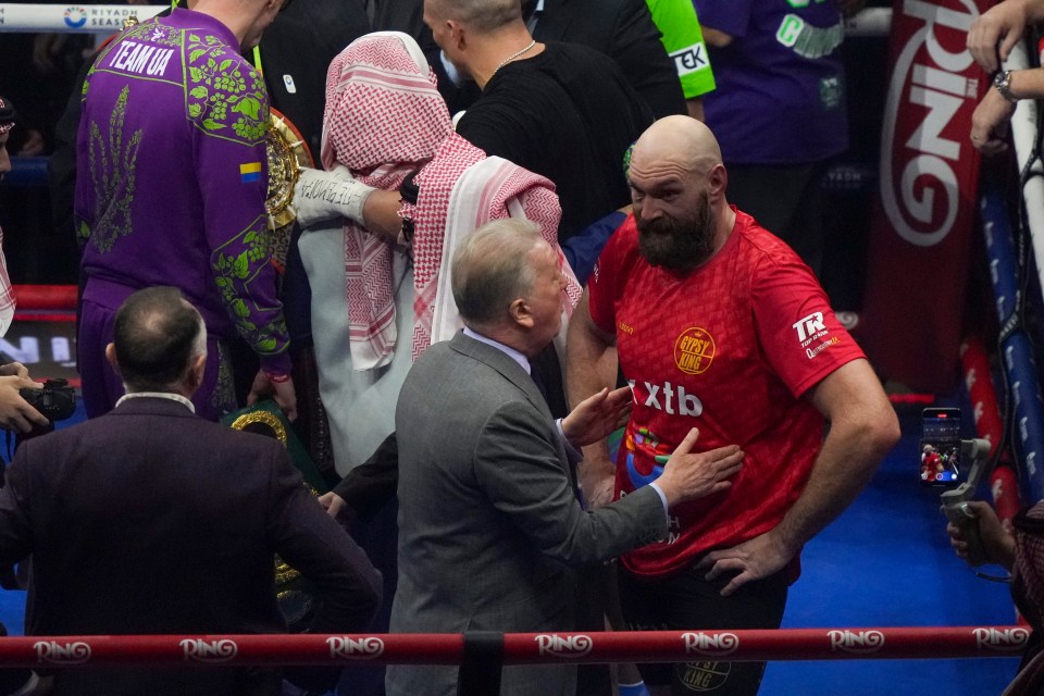 Tyson Fury speaks with his promoter after a boxing match.