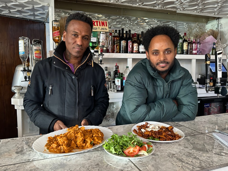 Two Eritrean brothers behind the bar of their pub, serving Eritrean food.