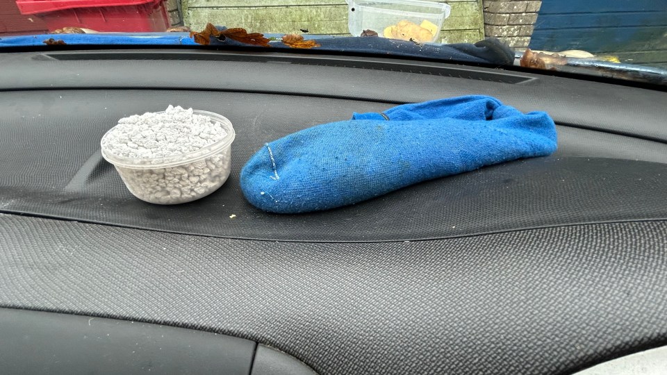 She fills a sock with cat litter, ties the end, and places it on the dashboard