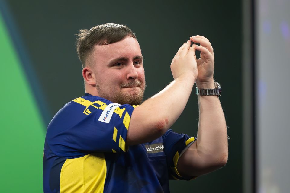 Luke Littler celebrates winning his third-round darts match.