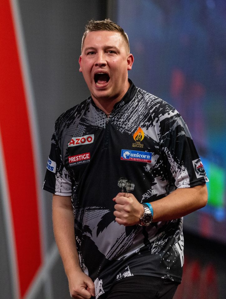 Chris Dobey celebrates a darts victory.