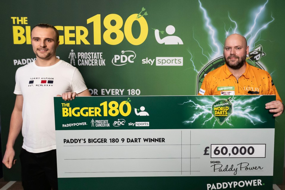 Christian Kist holding a Paddy Power World Darts Championship check for £60,000 for winning a 9-dart finish.