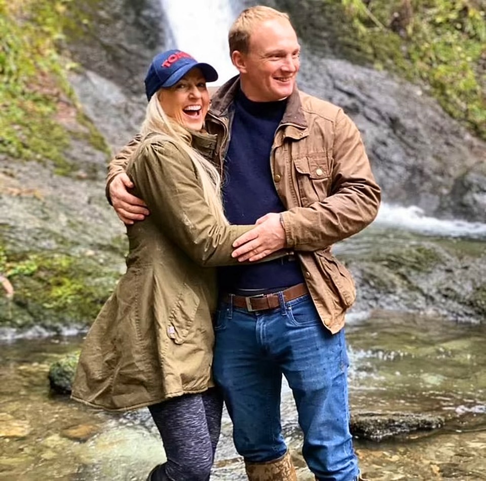 Christina Schmid and Adam Plumb embracing by a waterfall.