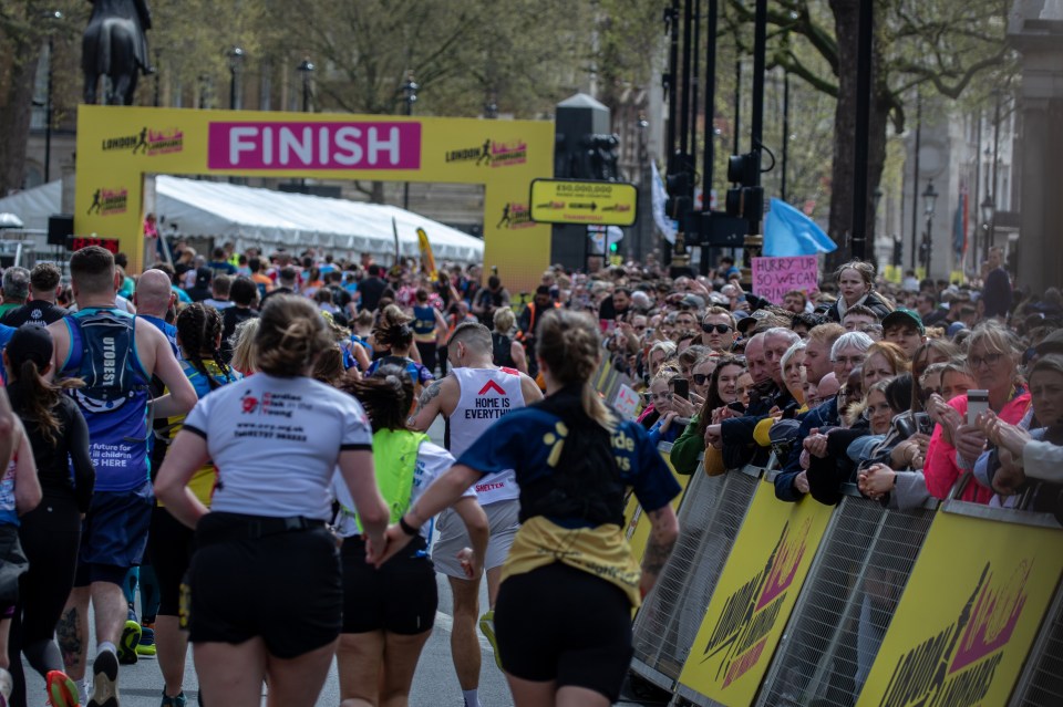 Runners holding hands as they approach the finish line at the London Landmarks Half Marathon