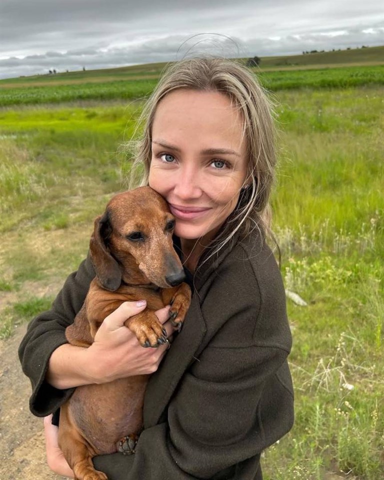 Woman holding a dachshund.