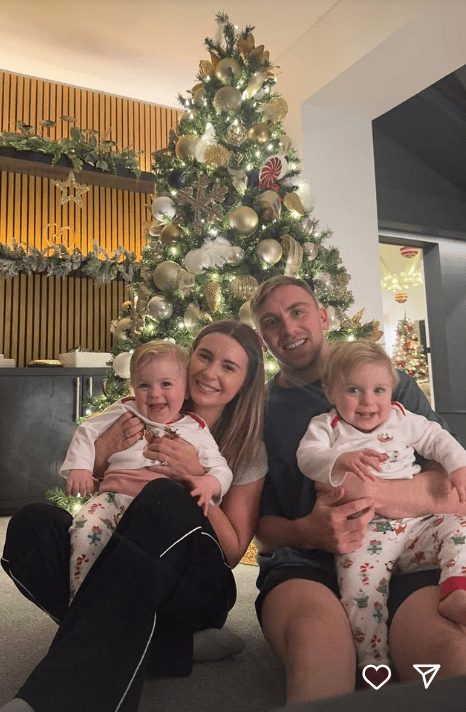 Family portrait in front of a Christmas tree.