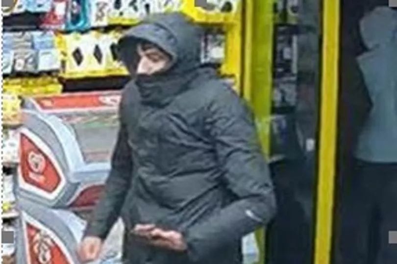 CCTV image of a suspect in a dark jacket with a hood.