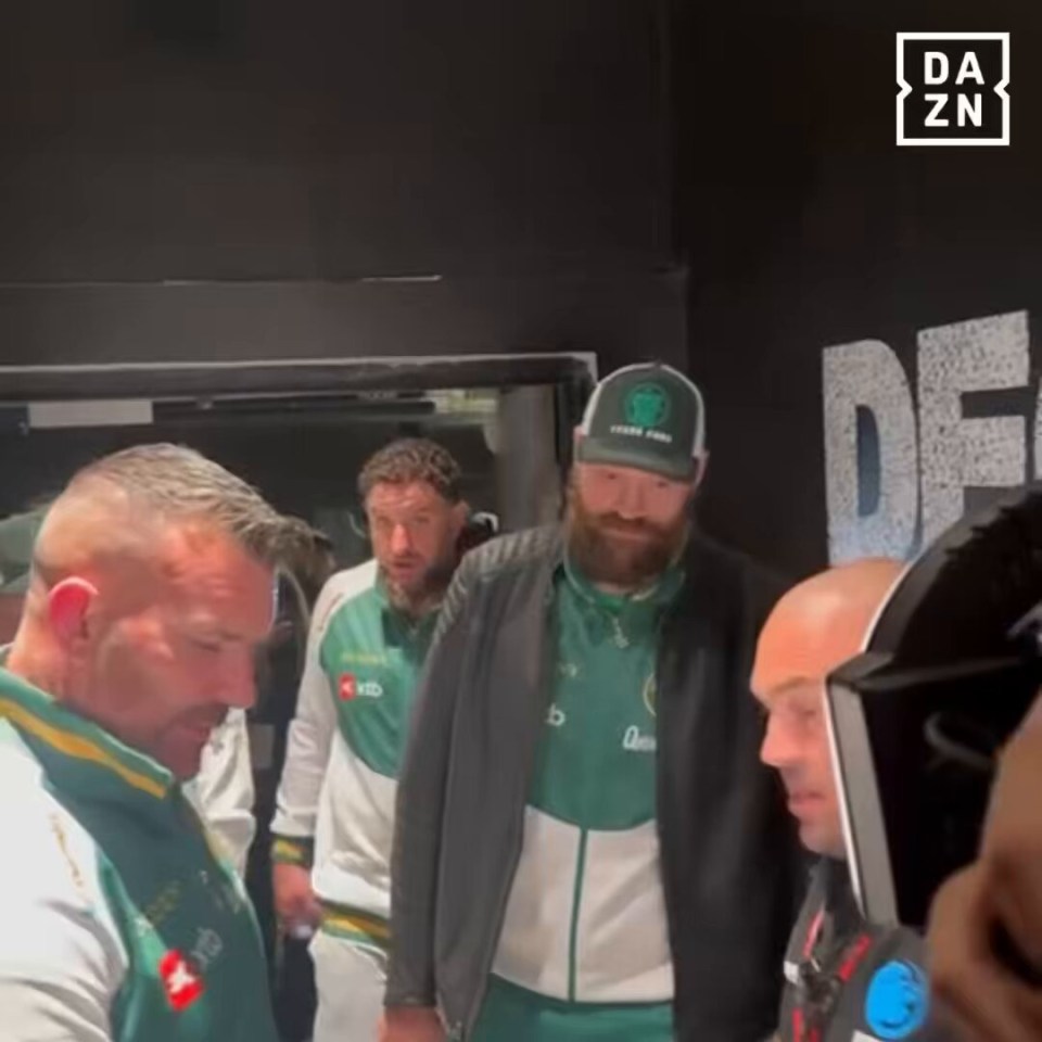 Boxers backstage in green jackets.