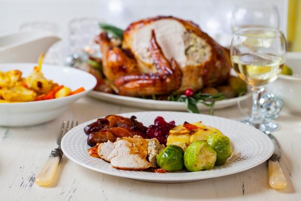 Christmas dinner plate with turkey, potatoes, brussels sprouts, and cranberry sauce.