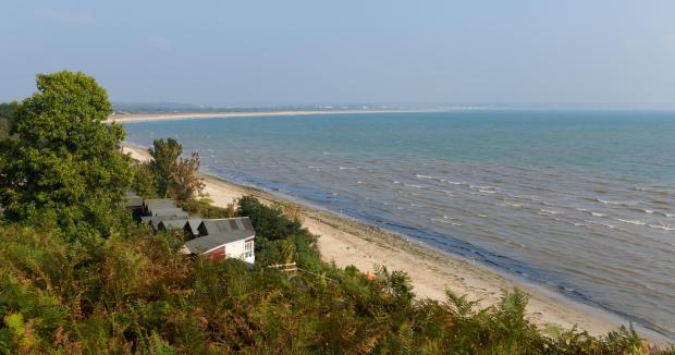 Beach huts overlooking Studland Bay in Dorset, England.