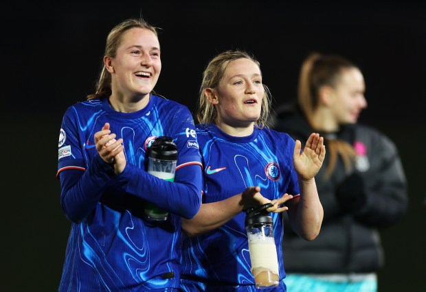 Erin Cuthbert and Wieke Kaptein of Chelsea FC applaud fans after a UEFA Women's Champions League match.