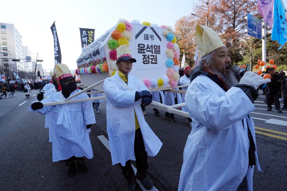 Farmers carry a coffin symbolising South Korean President Yoon Suk Yeol’s government on 14 December