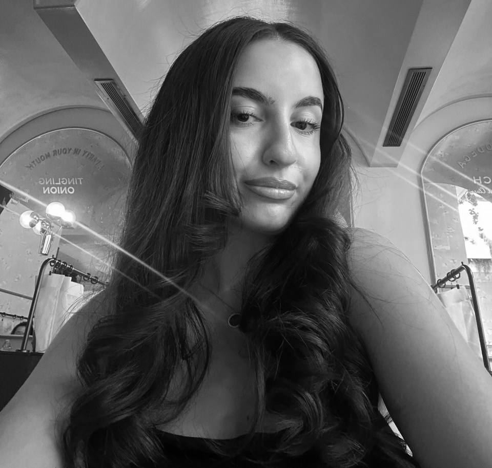 Black and white selfie of a young woman with long hair.