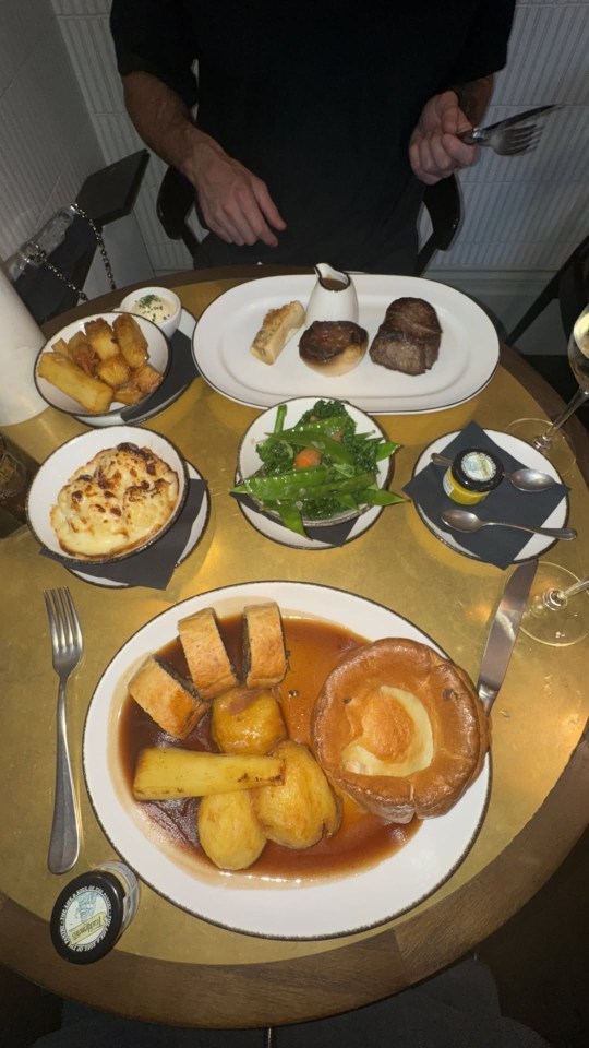 A table with a variety of dishes, including roast beef, Yorkshire pudding, and vegetables.