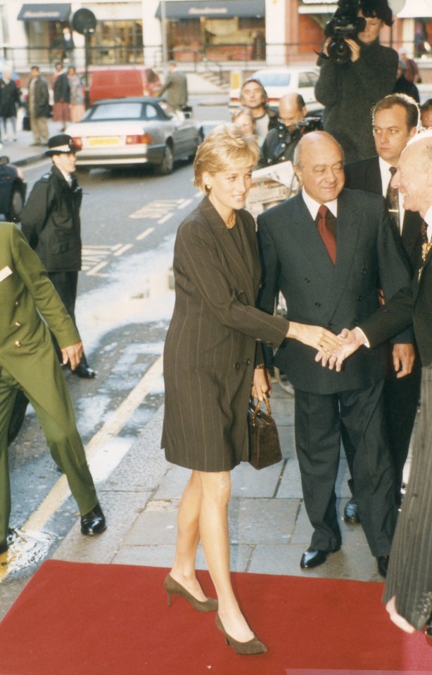 Princess Diana shaking hands with a man at a book launch.