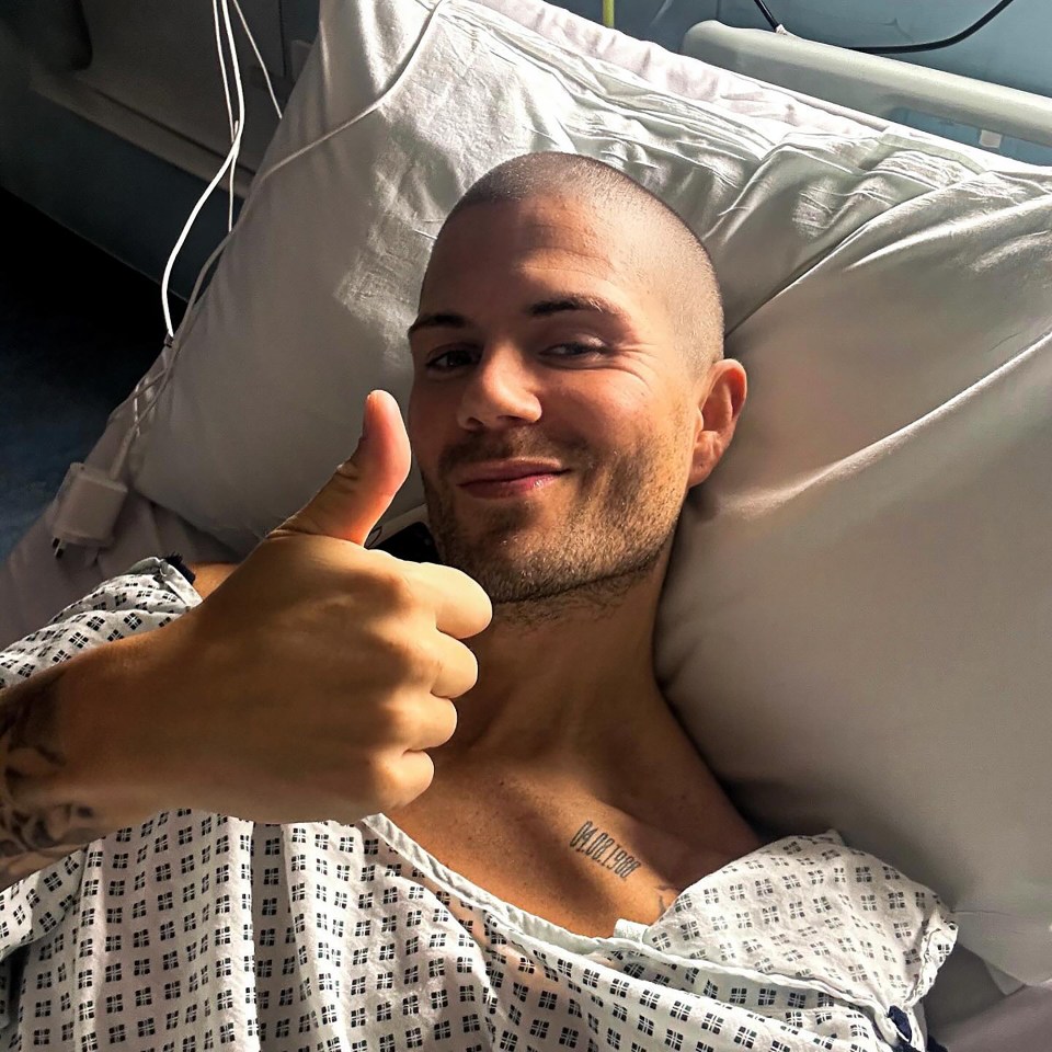 Man in hospital bed giving thumbs up.