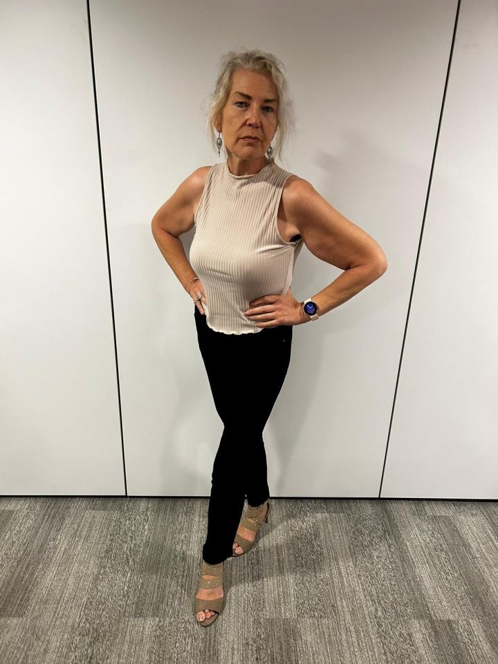 Woman in beige top and black pants.