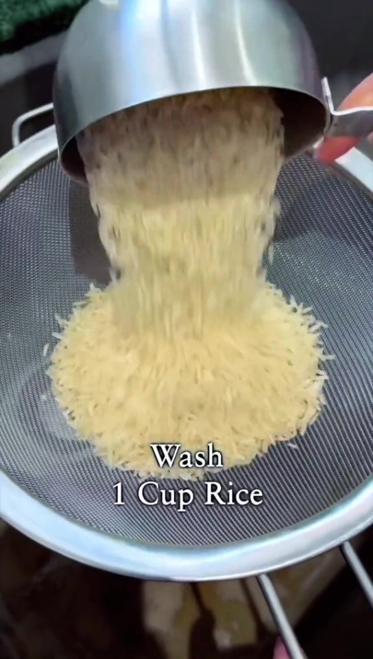 She first washes the rice before in a sieve