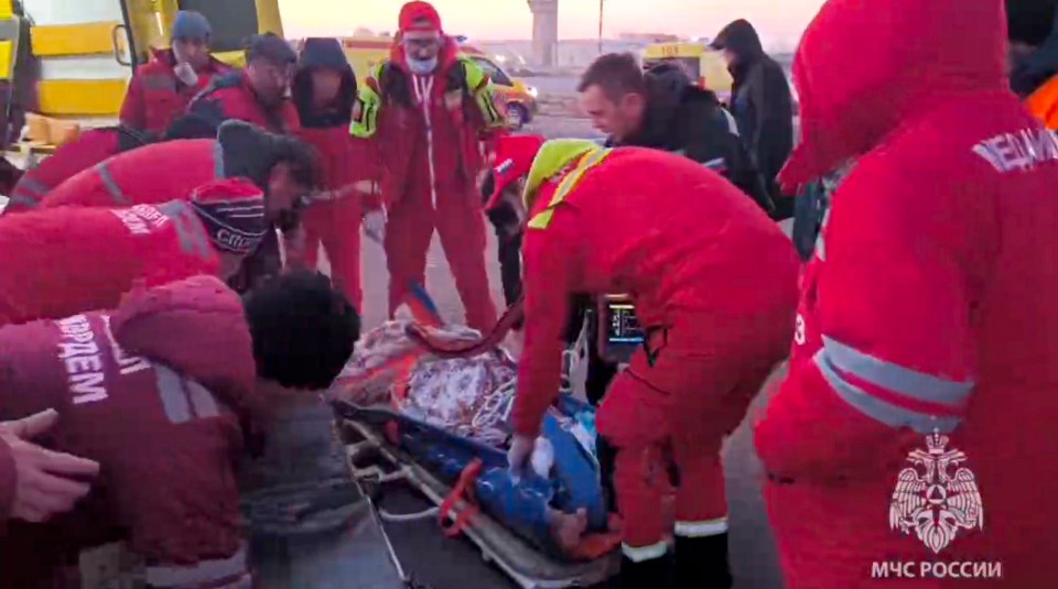 Rescuers prepare to carry a wounded passenger near the Kazakhstani city of Aktau