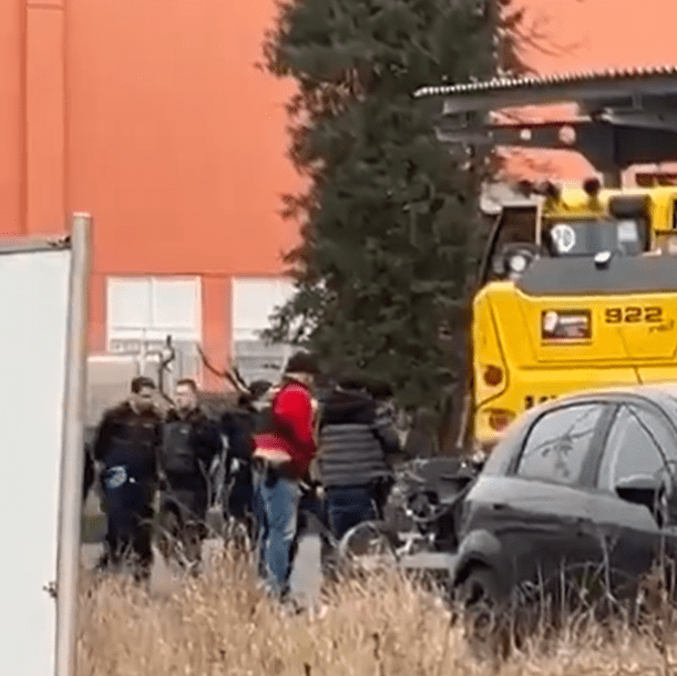 Police surround the excavator after the driver is shot