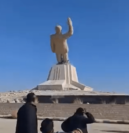 The moment a statue of former president Hafez al-Assad begins to topple backwards