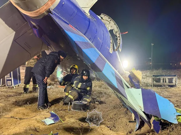 Emergency responders examining a damaged airplane.