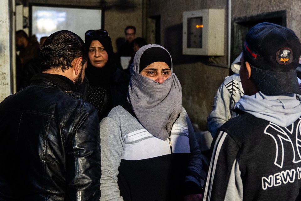 People searching for family members gather outside at Al Mujtahid Hospital to identify bodies