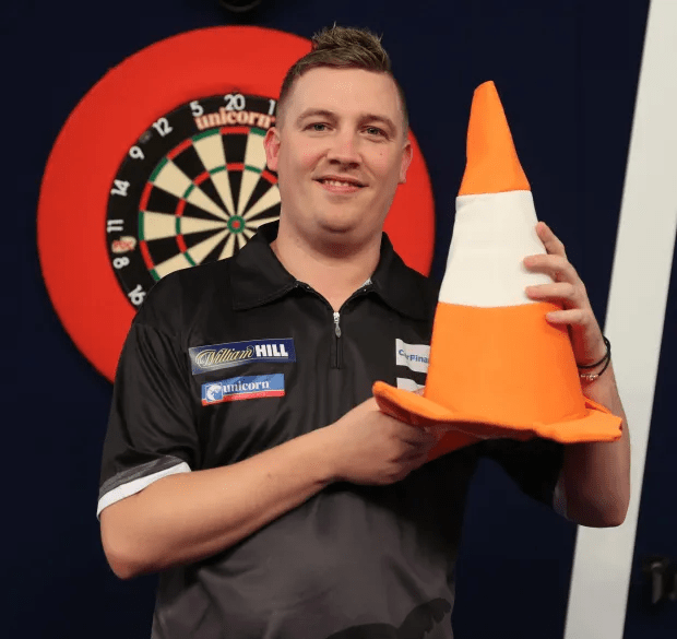 Darts player holding a traffic cone.