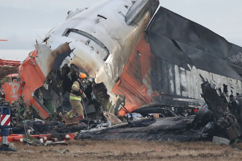 Firefighters work at the wreckage of a passenger plane at Muan International Airport which killed 179 people