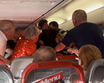 One passenger appears to bite the neck of another man onboard