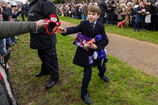 Prince Louis, six, was snapped with his hands full of presents during this year's walk